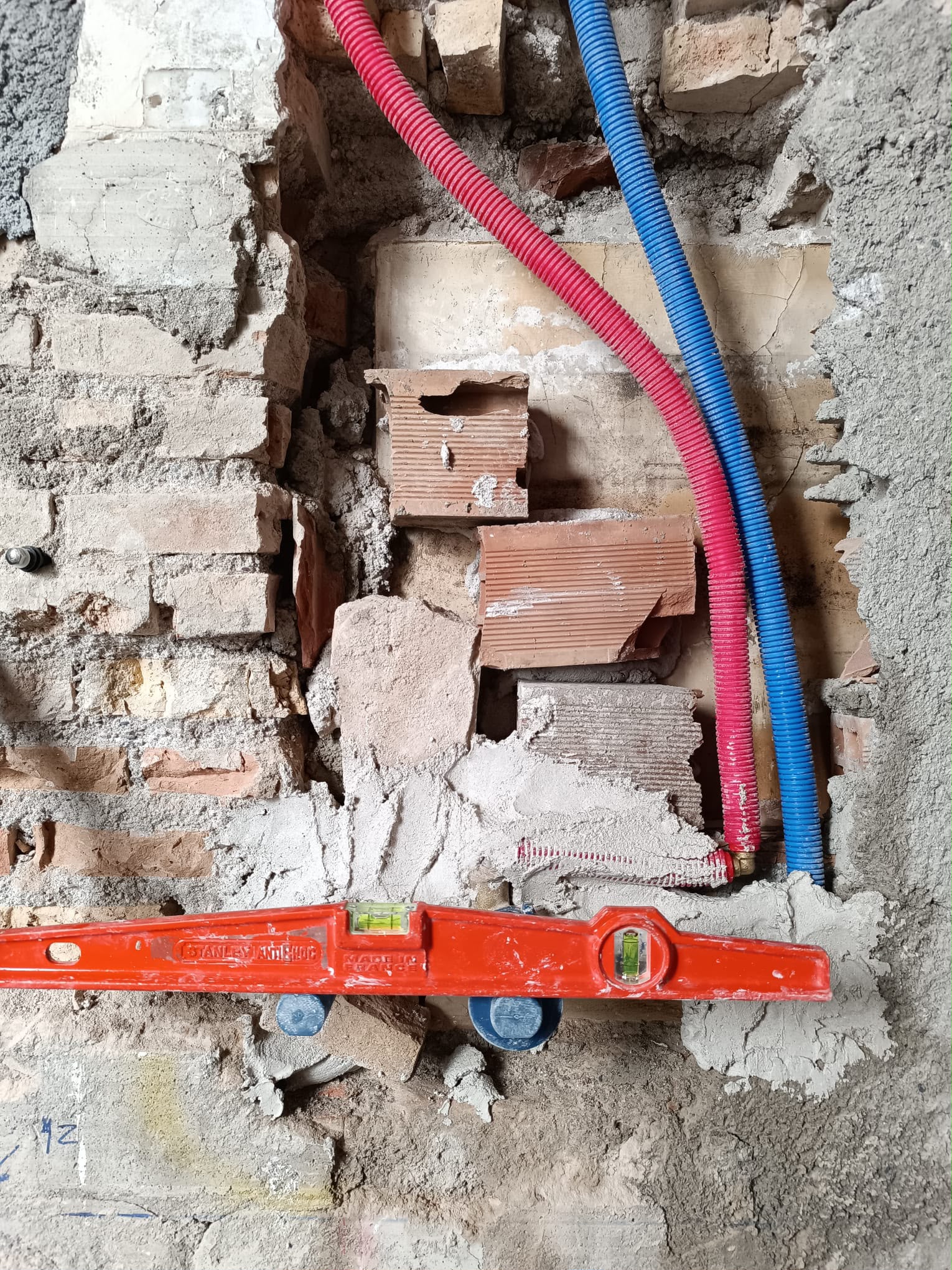 Reforma con tuberías en muro de ladrillo