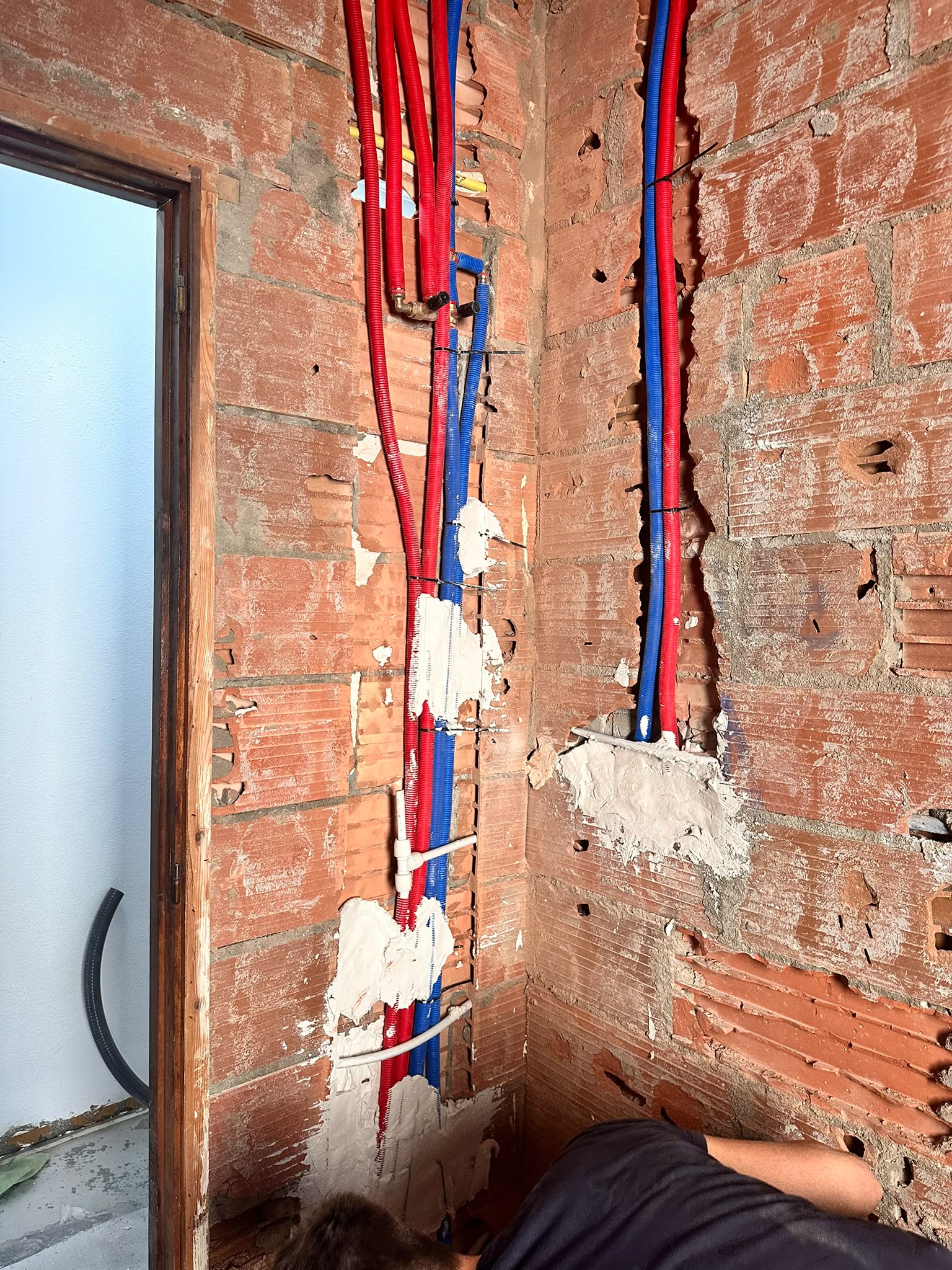 Tuberías rojas y azules en esquina de obra